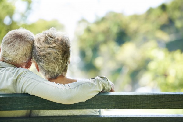 A happy senior couple relaxing together in their local park