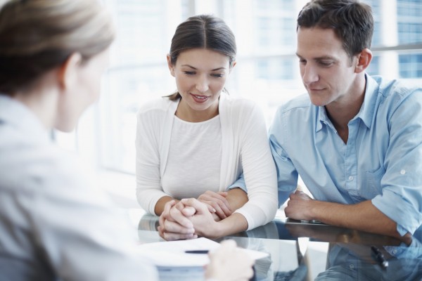 Shot of a consultant explaining a document to a young couple