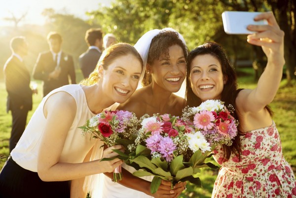 Shot of the bride and bridesmaids taking a selfie with a cellphone