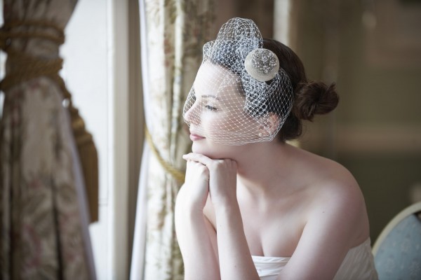 Pretty bride looking out of window and smiling on her wedding day