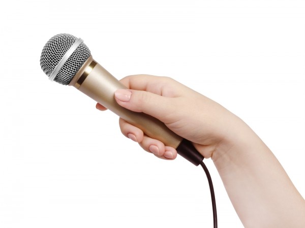Female hand with microphone, on white background.