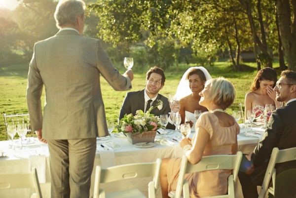 Rear view shot of a father making a toast at a wedding reception