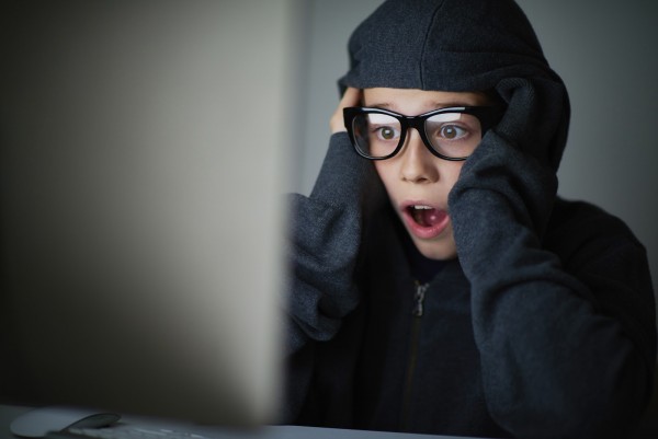 Frustrated boy with open mouth looking computer screen