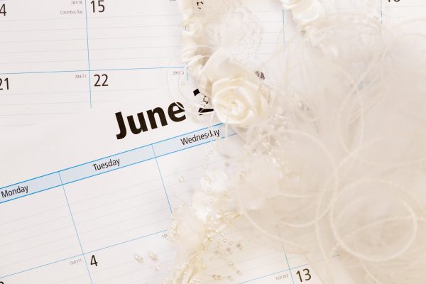 June calendar with bridal wedding veil. Summer weddings concept.