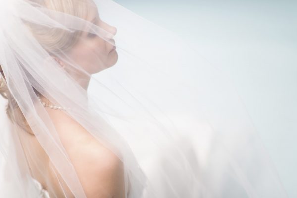 Close up beautiful lonely bride, light blue background, horizon format