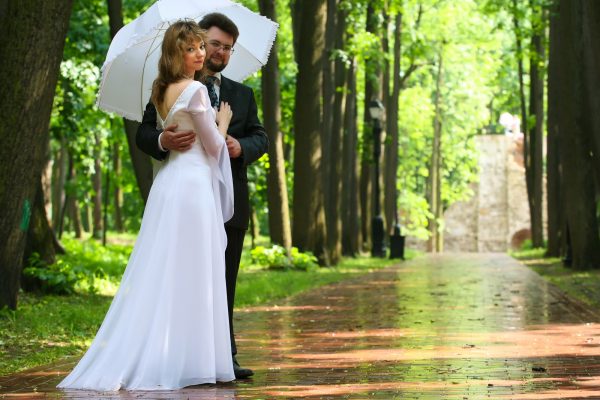 Just married ride and groom under rain