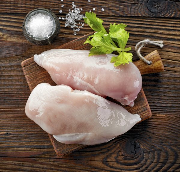 raw chicken fillets on wooden cutting board, top view