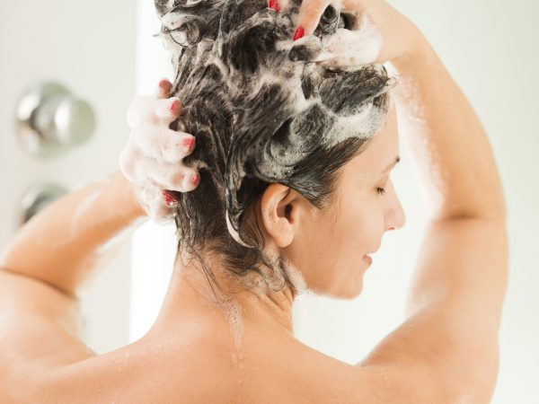 Mid adult woman washing a hear at domestic bathroom