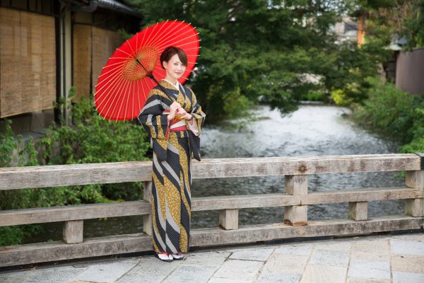 Japanese woman in traditional kimono holding an umbrella