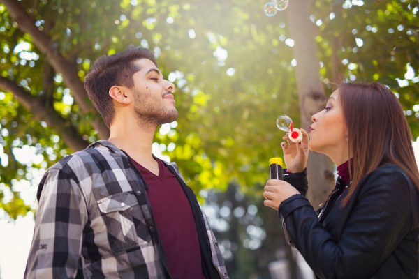 Couple Relaxing in the Park with bubble blower. Spring time.