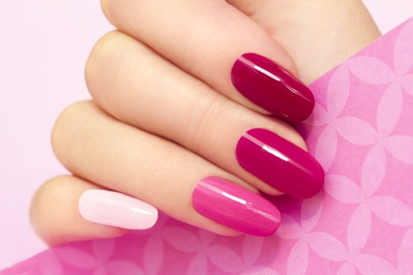 Multicolored manicure with different shades of pink nail Polish on women's hand