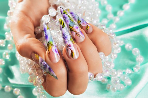 Female hand with beautiful floral design on nails.