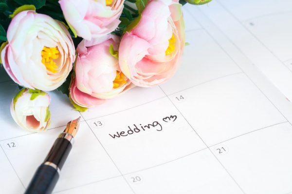 word wedding on calendar with sweet flowers and pen ,love concept
