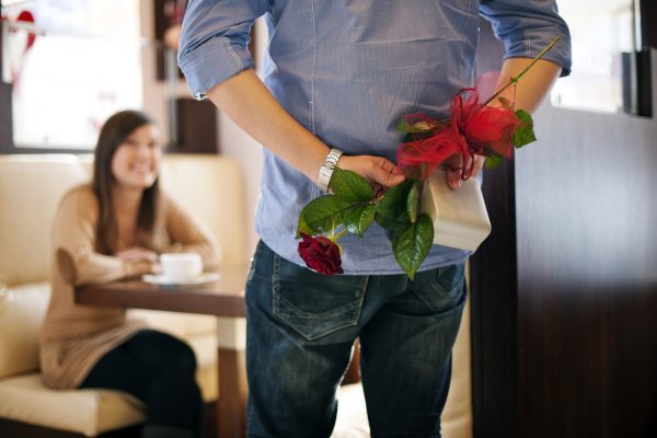 Young man giving a gift and flower his girlfriend on Valentine's Day