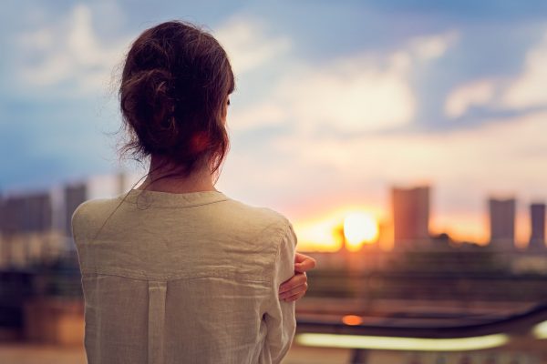 Young girl is watching sunset over Tokyo in Odaiba.